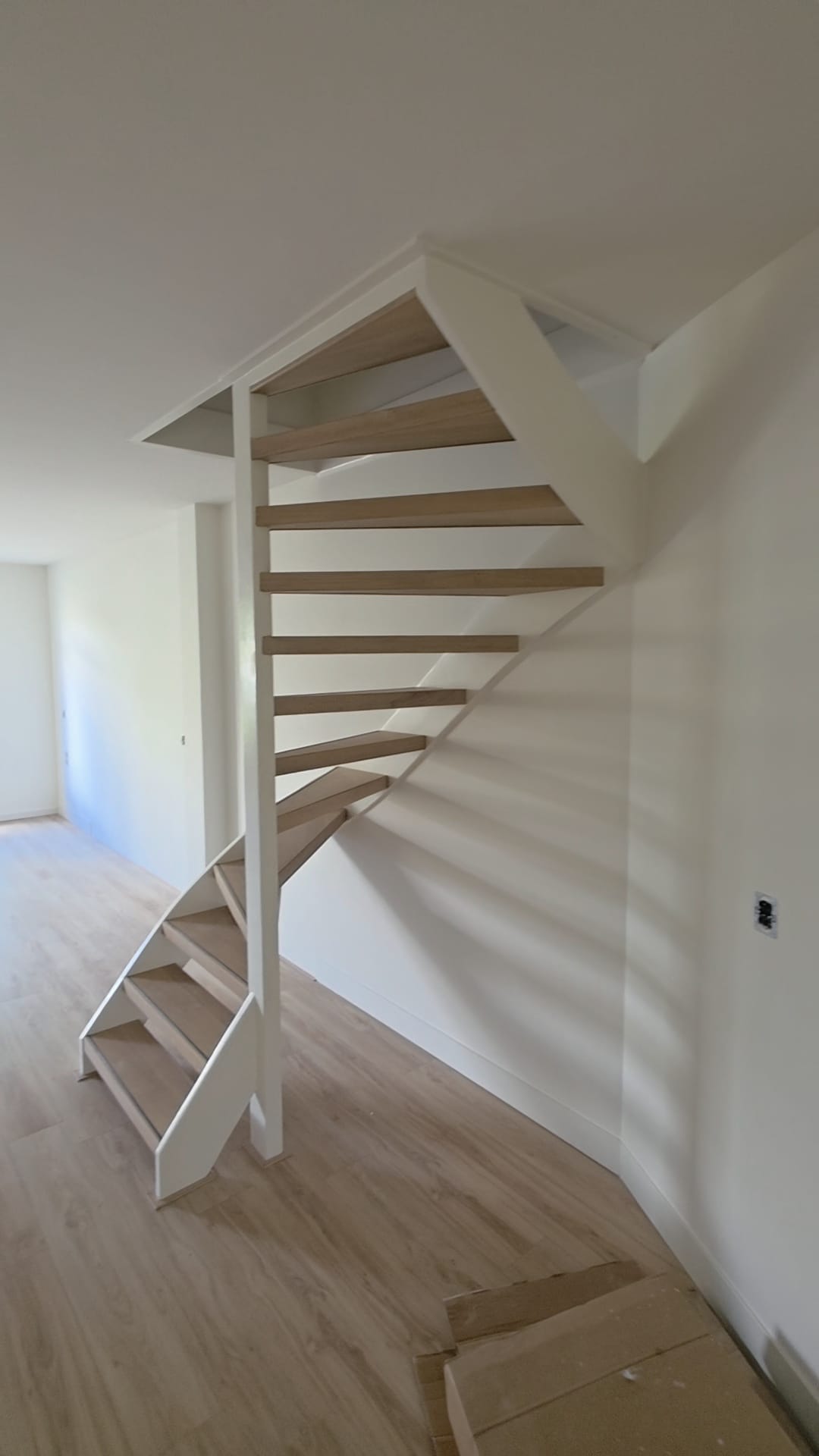 Opgeleverde gang met witte open trap en strakke wanden