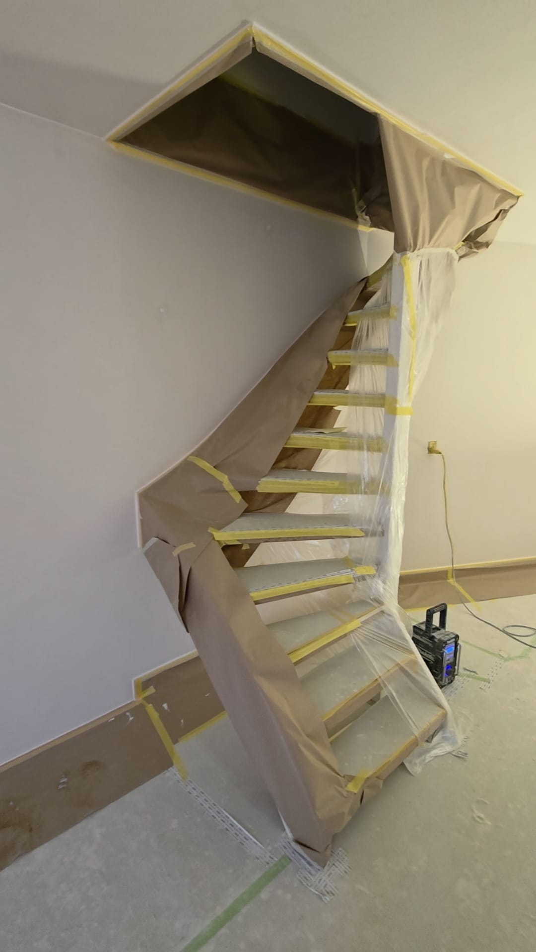 Trap volledig ingepakt met papier en tape tijdens het stucwerk